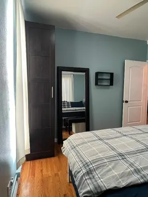 a bedroom with a bed and a mirror at Eco-Friendly Sunnyside 3 Bedroom Bungalow in Denver