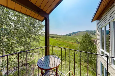 a balcony with a table and a view of a field at Mountainside 120 in Granby