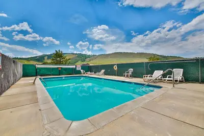 a swimming pool with chairs and a fence at Mountainside 120 in Granby