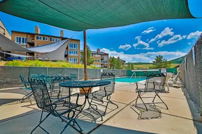 a patio with a table and chairs and a pool at Mountainside 001 in Granby
