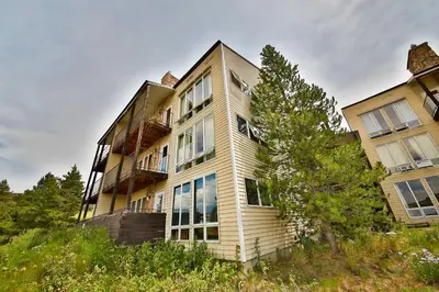 a large building with a tree in front of it at Mountainside 001 in Granby