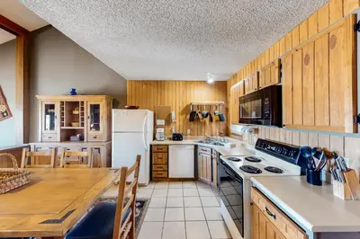a kitchen with wooden cabinets and a white refrigerator at Mountainside 037 in Granby