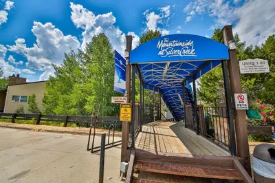 a bus stop with a blue canopy on a street at Mountainside 037 in Granby