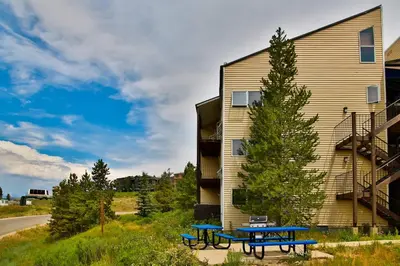 two picnic tables in front of a building at Mountainside 037 in Granby