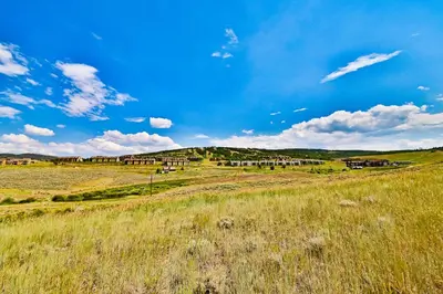 a field of grass with houses in the background at Mountainside 037 in Granby