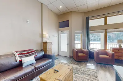 a living room with a leather couch and two chairs at Lakefront Keystone Studio in Keystone