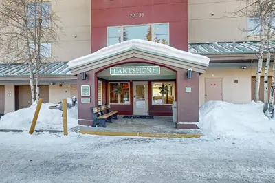 a building with a bench in the snow in front at Lakefront Keystone Studio in Keystone