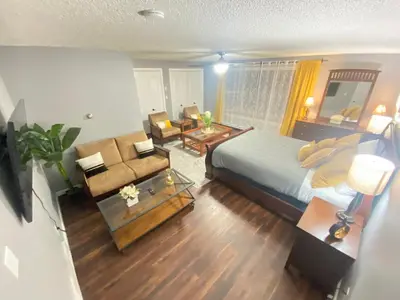 a bedroom with a large bed and a living room at Stylish two homes in one house 6 bedrooms 2 kitchens in Longmont
