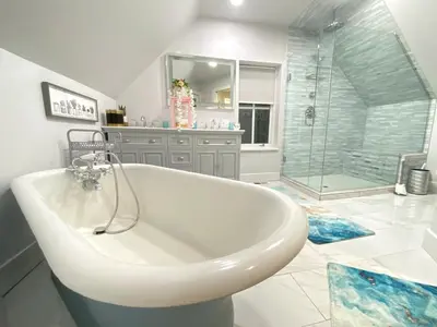 a white bath tub in a bathroom with a shower at More than 100 years modern house, 3 rooms whit kids playground in Longmont