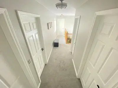 a hallway with two white doors and a stairway at Bright, big home walking distance to Mcintosh lake in Longmont