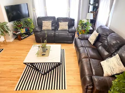 a living room with a leather couch and a coffee table at Bright, big home walking distance to Mcintosh lake in Longmont