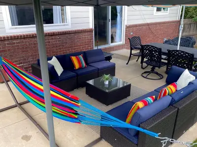 a colorful hammock sitting on a patio under an umbrella at Bright, big home walking distance to Mcintosh lake in Longmont