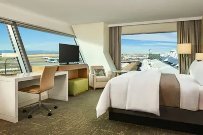 a hotel room with a bed and a desk and a large window at The Westin Denver International Airport in Denver