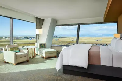 a bedroom with a large bed and a view of an airport at The Westin Denver International Airport in Denver