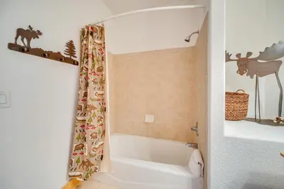 a bathroom with a tub and a shower curtain with animals at 6 Mi to Keystone Resort Dillon Condo with Balcony in Dillon