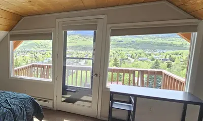 a bedroom with a bed and a balcony with sliding glass doors at Palmers Dr 1010 in Silverthorne