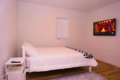 a white bedroom with a bed and a picture on the wall at Cozy Home near Gaylord Rockies Resort & Denver Airport in Aurora