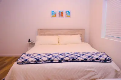 a bedroom with a bed with a white bedspread at Cozy Home near Gaylord Rockies Resort & Denver Airport in Aurora