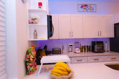 a kitchen with white cabinets and a yellow object on the counter at Cozy Home near Gaylord Rockies Resort & Denver Airport in Aurora