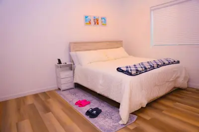 a bedroom with a bed and a pair of shoes on a rug at Cozy Home near Gaylord Rockies Resort & Denver Airport in Aurora