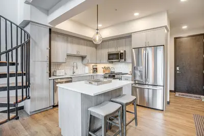 a kitchen with a large island with two stools at Walk to Cooper Creek Square Condo with Hot Tub! in Winter Park