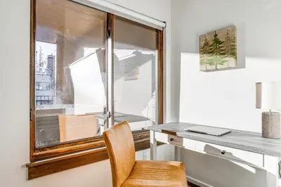 a desk and a chair in a room with a window at Walk to Cooper Creek Square Condo with Hot Tub! in Winter Park
