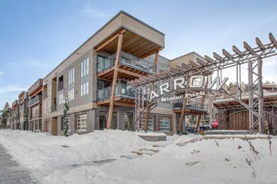 a building in the winter with snow around it at Walk to Cooper Creek Square Condo with Hot Tub! in Winter Park