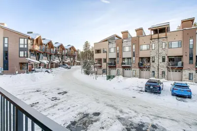 a snow covered street in front of apartment buildings at Walk to Cooper Creek Square Condo with Hot Tub! in Winter Park