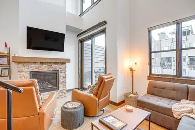 a living room with a couch and a fireplace at Walk to Cooper Creek Square Condo with Hot Tub! in Winter Park