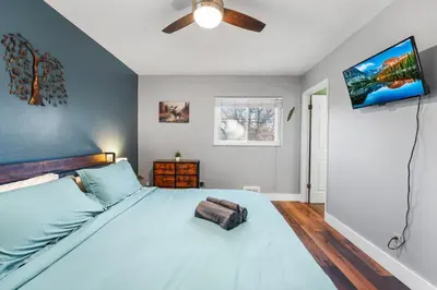 a bedroom with a large bed with a ceiling fan at Creekside Family Haven in Arvada