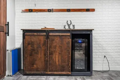 a wooden cabinet against a white wall with a shelf at Creekside Family Haven in Arvada