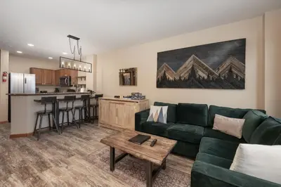 a living room with a green couch and a table at Premium Unit 2216 - 1 Br - Zephyr Mountain Lodge condo in Winter Park