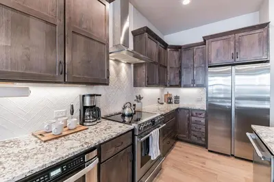 a kitchen with wooden cabinets and stainless steel appliances at Lovely Townhome at the TPC Golf Course in Berthoud