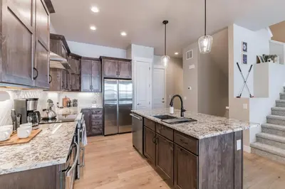 a kitchen with wooden cabinets and a large counter top at Lovely Townhome at the TPC Golf Course in Berthoud