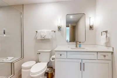 a bathroom with a toilet and a sink and a mirror at Skywalk Flats Escape in Silverthorne