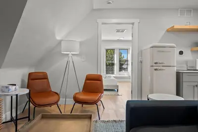 a living room with two chairs and a kitchen at Broadway Dog-Friendly Loft with Parking in Denver