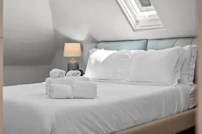 a white bed with two stuffed animals on it at Broadway Dog-Friendly Loft with Parking in Denver