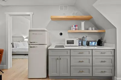 a kitchen with a refrigerator and a microwave at Broadway Dog-Friendly Loft with Parking in Denver