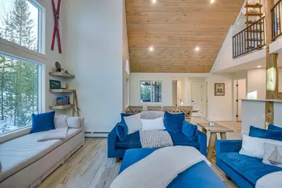a living room with blue couches and a wooden ceiling at Mtn Escape with Hot Tub, By Trails in Grand Lake! in Grand Lake