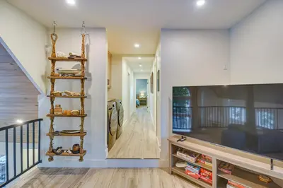 a living room with a spiral book shelf and a staircase at Mtn Escape with Hot Tub, By Trails in Grand Lake! in Grand Lake