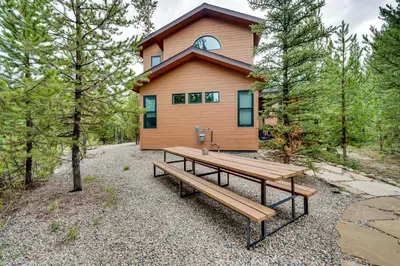a house with a picnic bench in front of it at Mtn Escape with Hot Tub, By Trails in Grand Lake! in Grand Lake