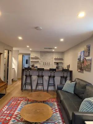 a living room with a couch and tables and a bar at Cliff's Edge Brewing BBnB in Denver
