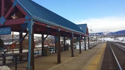a train station with a blue roof and a platform at Best Ski Condo, Winter Park, USA in Winter Park