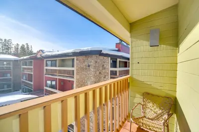 a balcony with a chair and a building at Pool and Hot Tub Access Condo in Winter Park! in Winter Park