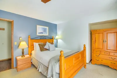 a bedroom with a wooden bed and a wooden dresser at Pool and Hot Tub Access Condo in Winter Park! in Winter Park