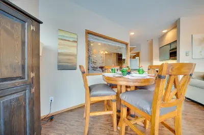 a kitchen and dining room with a wooden table and chairs at Steps to River Run Gondola Ski Condo with Views! in Keystone