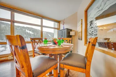 a dining room with a table and chairs and a window at Steps to River Run Gondola Ski Condo with Views! in Keystone