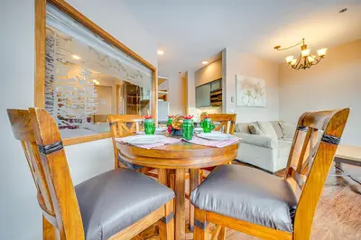 a dining room and living room with a table and chairs at Steps to River Run Gondola Ski Condo with Views! in Keystone
