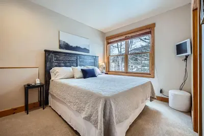 a bedroom with a large bed and a window at 6 Cabin in the Pines home in Keystone
