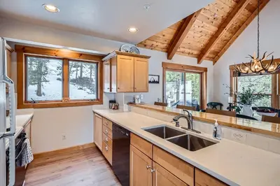 a kitchen with wooden cabinets and a sink at 6 Cabin in the Pines home in Keystone